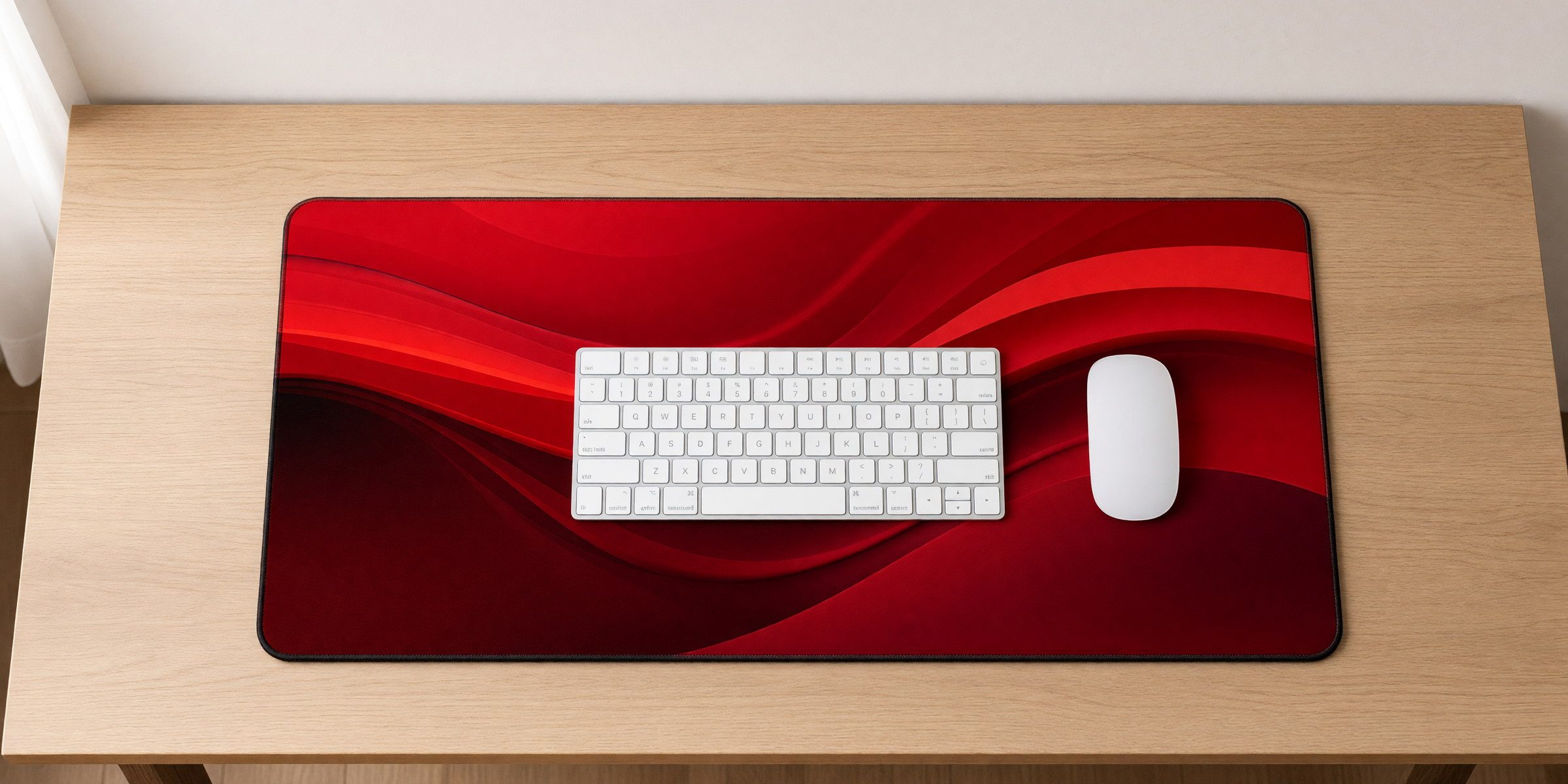 Overhead view of an extended desk mat centered on a wide desk with a keyboard and mouse